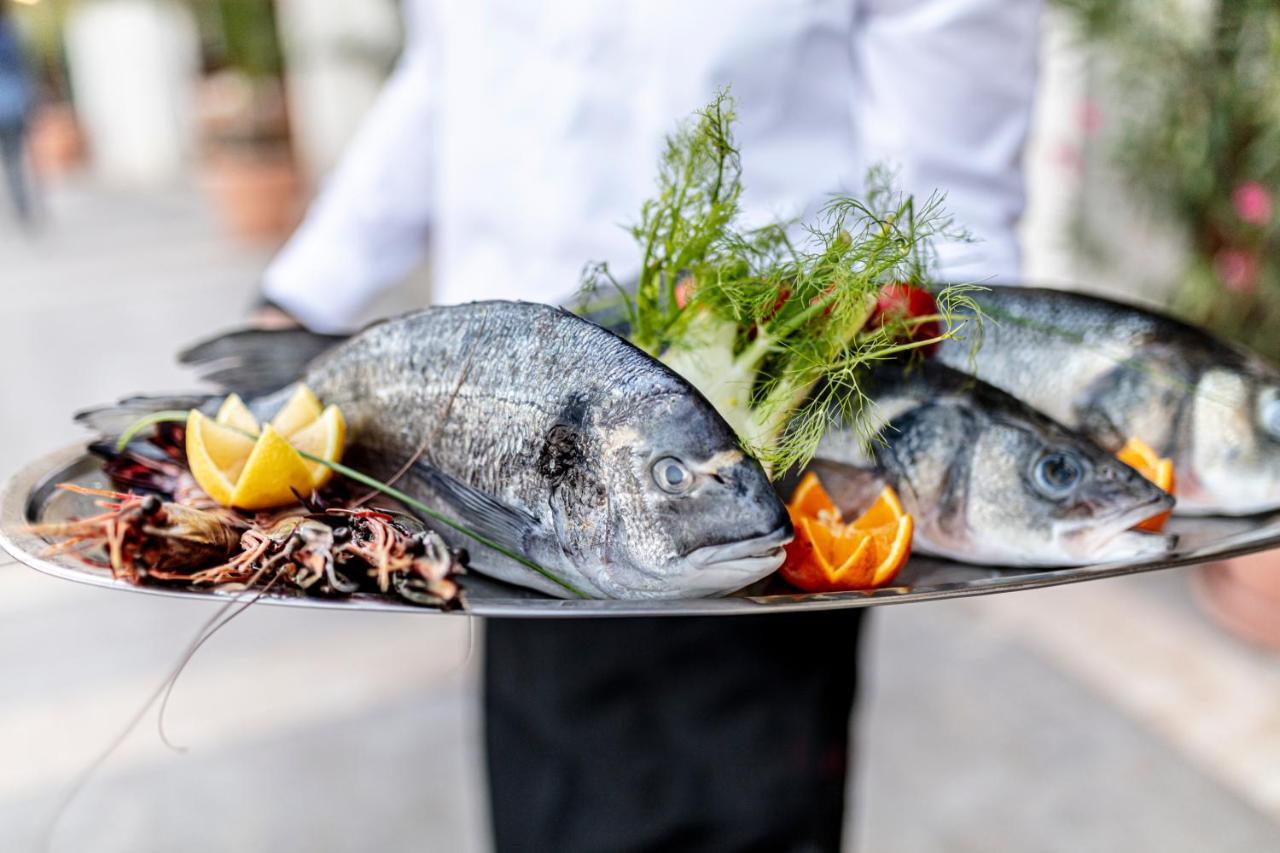 فندق لايتهاوس غولف وسبا بالشيك المظهر الخارجي الصورة A waiter holding a platter of fish